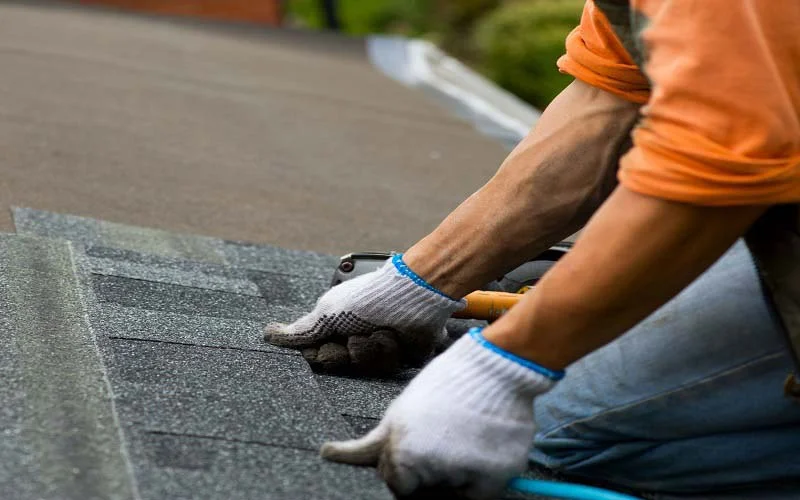 process of laying new asphalt shingles during roof repair